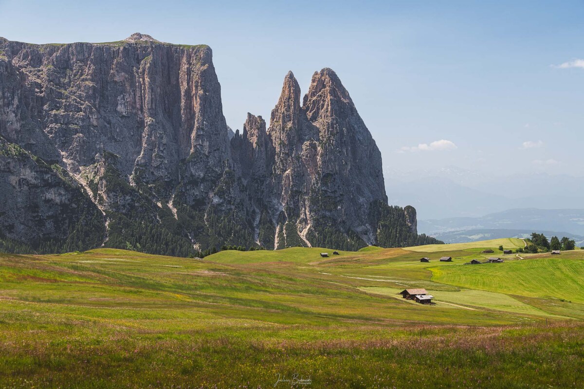 Chalets et ondulations vertes de l'Alpe di Siusi dans les Dolomites